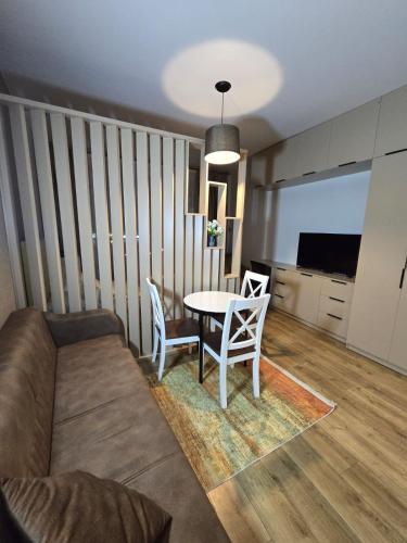 a living room with a couch and a table and chairs at Luxury Suites White Sails in Batumi