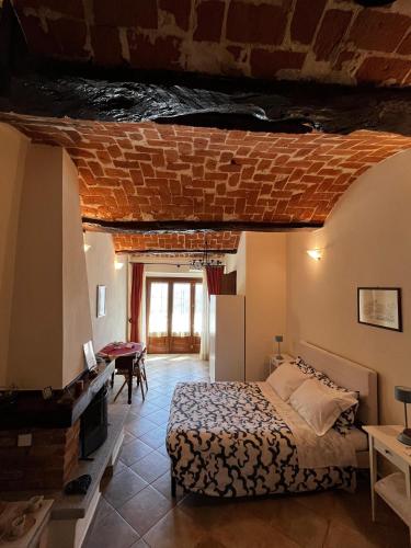 a bedroom with a bed and a brick ceiling at An tij slè - Nel cuore del borgo in Guarene