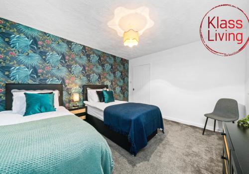 a bedroom with two beds and a wall with plants at Colt Apartment by Klass Living Coatbridge in Glenboig