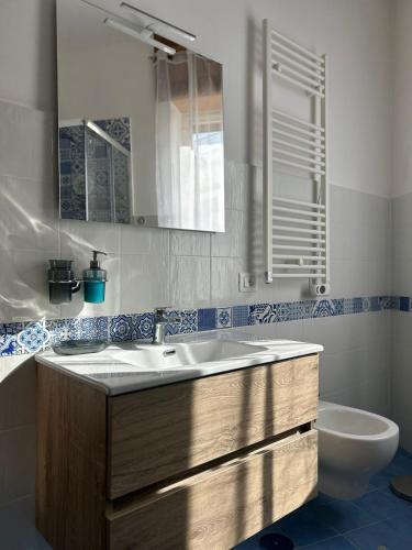 a bathroom with a sink and a toilet and a mirror at Massi's House - Cozy & New in Maiori