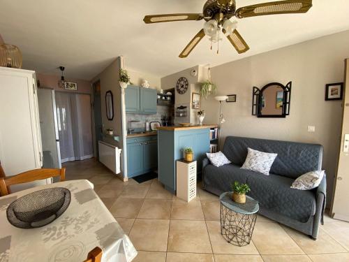 un salon avec un canapé et une cuisine dans l'établissement Appartement cosy avec jardinet privé à 5 min des Thermes - FR-1-503-74, à Balaruc-les-Bains