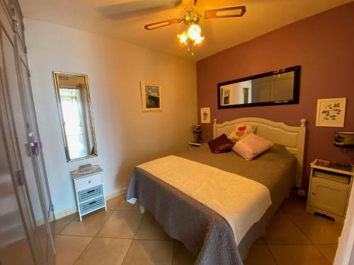 une chambre avec un lit, un miroir et une fenêtre dans l'établissement Appartement cosy avec jardinet privé à 5 min des Thermes - FR-1-503-74, à Balaruc-les-Bains