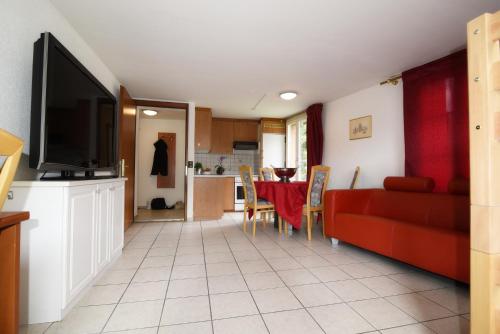 a living room with a red couch and a table at Residence Jungfrau in Interlaken