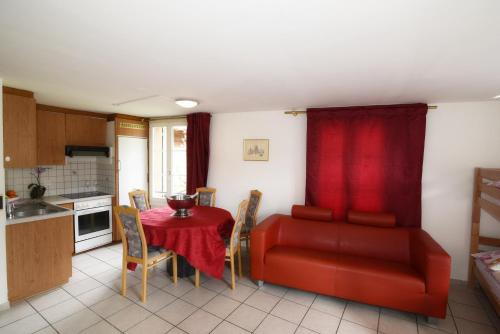 a living room with a red couch and a table at Residence Jungfrau in Interlaken
