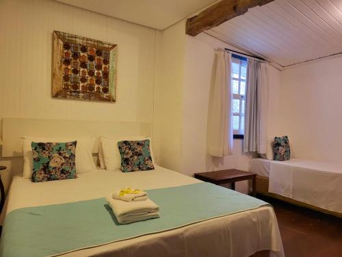 a bedroom with two beds and a window at Pousada Do Ó in Tiradentes