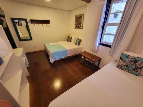 a small room with a bed and a table at Pousada Do Ó in Tiradentes