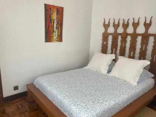 a bed with a wooden headboard in a room at Marciloui in Antsirabe