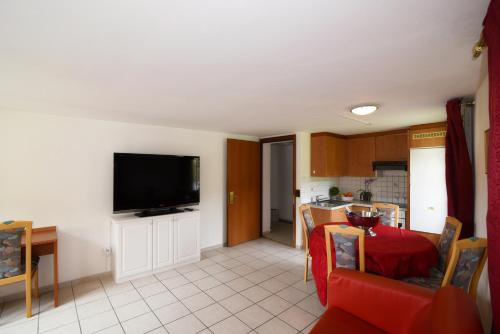 a living room with a table and a television on a wall at Residence Jungfrau in Interlaken