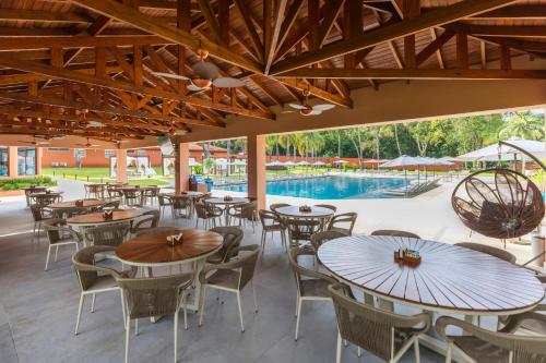 a patio with tables and chairs and a pool at Sanma Hotel in Foz do Iguaçu