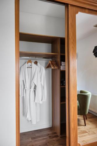 a closet with a white robe hanging in it at Carnbore House BnB in Bushmills