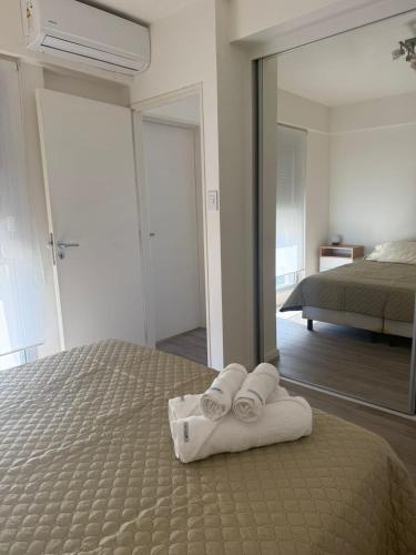 a bedroom with a bed with towels and a mirror at Departamento de un dormitorio - FRANCIA in Santa Fe