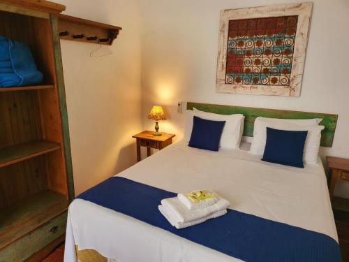 a bedroom with a bed with towels on it at Pousada Do Ó in Tiradentes