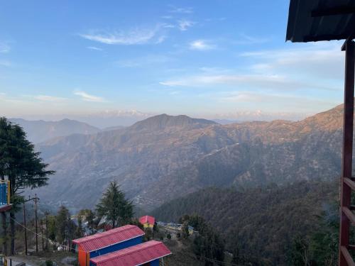 a view of a mountain valley with mountains at heights of dhanaulti a 360 view guest house in Dhanaulti