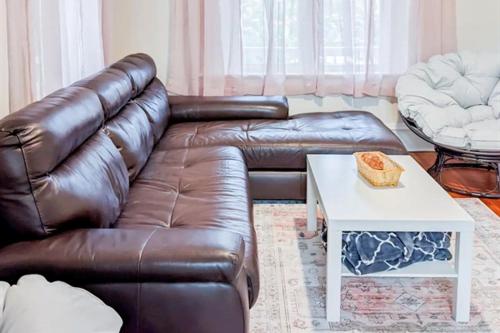 a living room with a brown leather couch and a table at Luxury Beach Getaway in Cape Charles in Cape Charles