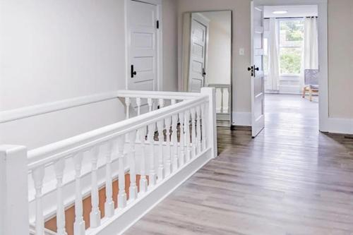 a white room with a staircase and a white door at Luxury Beach Getaway in Cape Charles in Cape Charles