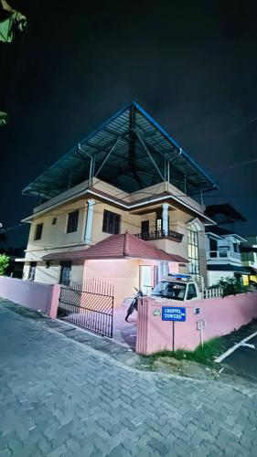 a house with a fence in front of it at Empire Hostel in Ernakulam