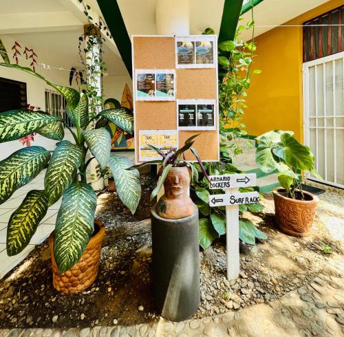 a sign in a room with plants and a statue at Palmar la Punta 5 Starlink 2min walk to the beach in Brisas de Zicatela