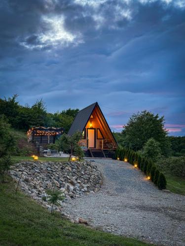 a log cabin with lights on a gravel road at Vila Miorita in Sebeş