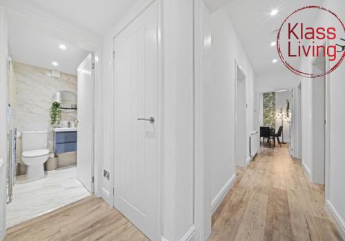 a hallway with white walls and a toilet in a house at Drumpellier Apartment by Klass Living Coatbridge in Coatbridge