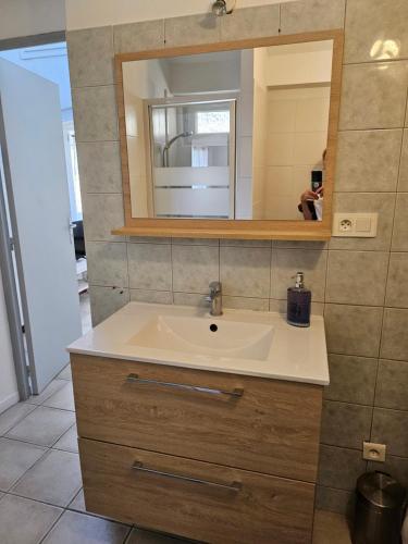 une salle de bain avec un lavabo et un miroir dans l'établissement Agréable T2 au centre ville, à Manosque