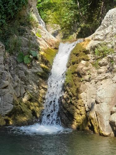 a waterfall on the side of a rocky cliff at To σαλέ της λίμνης 2 in Kalyvia Fylaktis