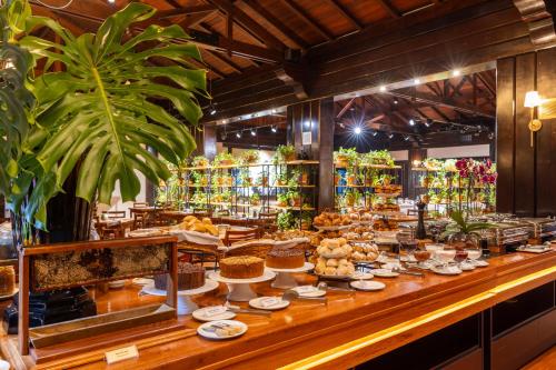 a bakery with a buffet of food on a counter at Sanma Hotel in Foz do Iguaçu