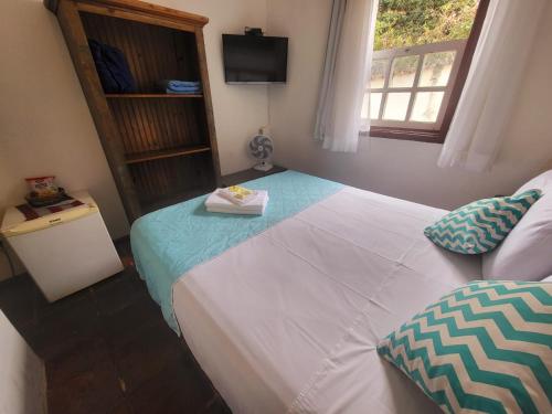 a bedroom with a large bed and a window at Pousada Do Ó in Tiradentes