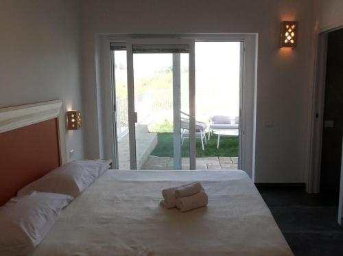 a white bed with a towel on top of it at Amarena Garden House in Matera