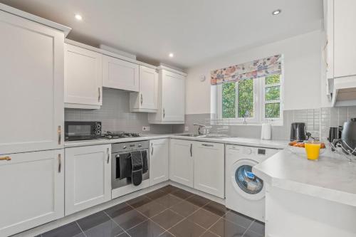 a kitchen with white cabinets and a dishwasher at Zuri Luxe Birmingham - Home Away From Home in Birmingham