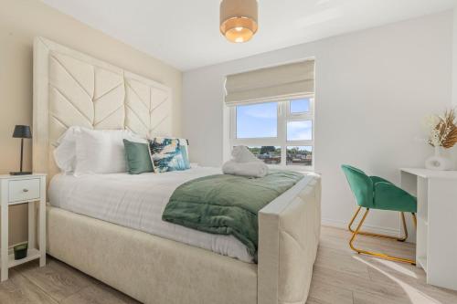 a bedroom with a bed and a green chair at Zuri Luxe Birmingham - Home Away From Home in Birmingham