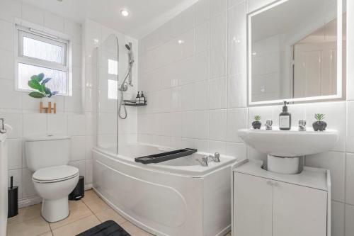 a white bathroom with a toilet and a sink at Zuri Luxe Birmingham - Home Away From Home in Birmingham
