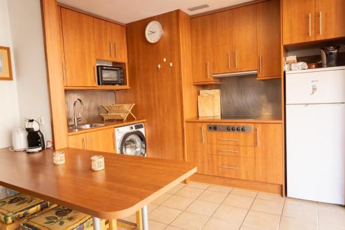 a kitchen with a table and a white refrigerator at Casa Simar in Playa Jandia