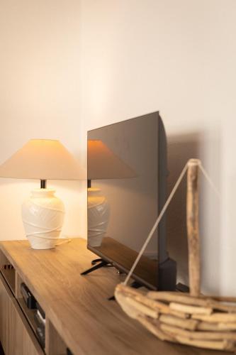 a tv sitting on a dresser with a lamp and a lamp at Casa Simar in Playa Jandia