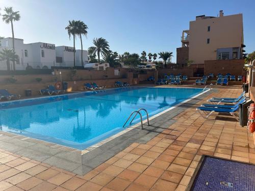 a large swimming pool with blue water in a resort at Casa Simar in Playa Jandia