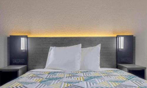 a bedroom with a bed with two night stands and two lamps at Studio 6 Little Rock AR South in Little Rock