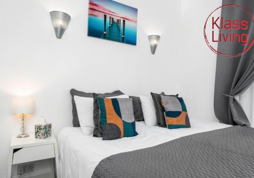 a bedroom with a bed with white sheets and pillows at Elmbank Apartment by Klass Living Bellshill in Bellshill