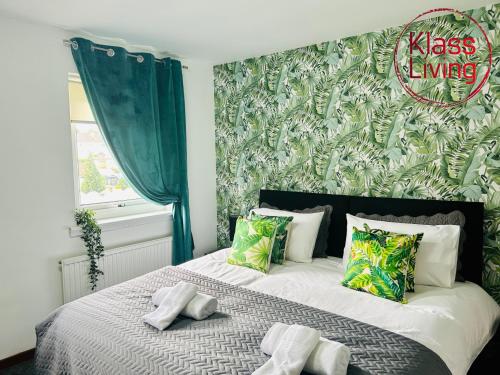a bedroom with a bed with a green wall at Elmbank Avenue House by Klass Living Uddingston in Uddingston