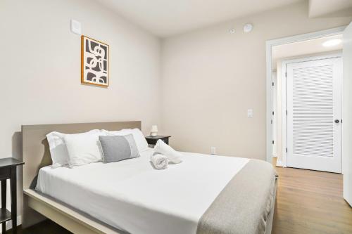 Un dormitorio blanco con una cama grande y una ventana. en Comfy Clarendon Apt - Steps from Metro, en Arlington