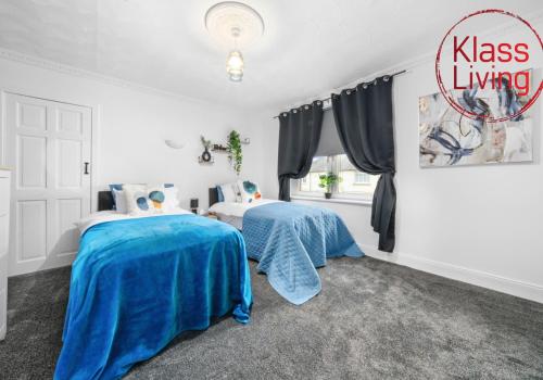 a bedroom with two beds with blue sheets at Fraser House by Klass Living Rutherglen in Glasgow