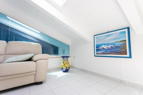 a living room with a couch and a painting on the wall at Agropoli Home in Agropoli