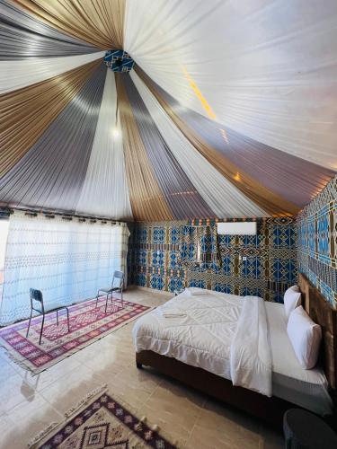 a bedroom with a bed in a tent at RUM FLORAA LUxURY CAMP in Wadi Rum