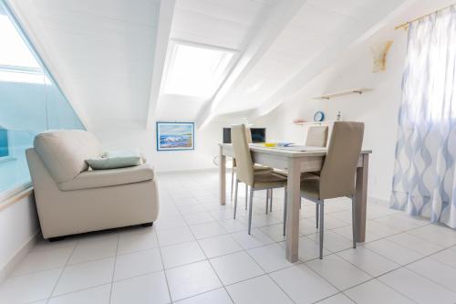 a white dining room with a table and chairs at Agropoli Home in Agropoli