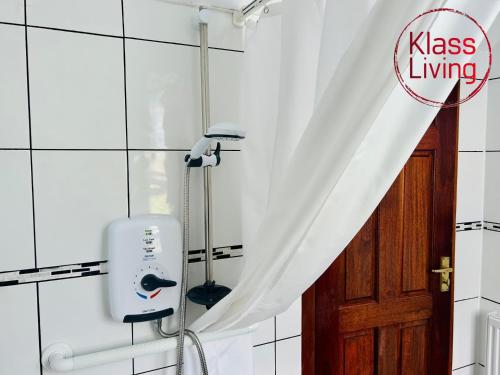 a hair dryer in a bathroom with a shower curtain at Elmbank Avenue House by Klass Living Uddingston in Uddingston