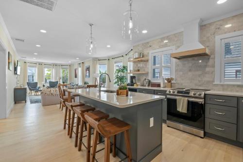 a large kitchen with a large island with bar stools at Downtown Salem Gem 3BR, Patio & Easy Parking in Salem
