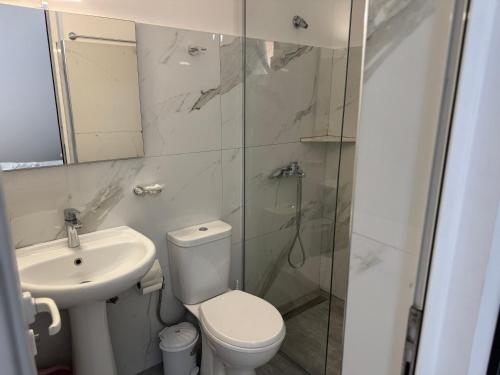 a bathroom with a toilet and a sink and a shower at Apartments Klajdi in Sarandë