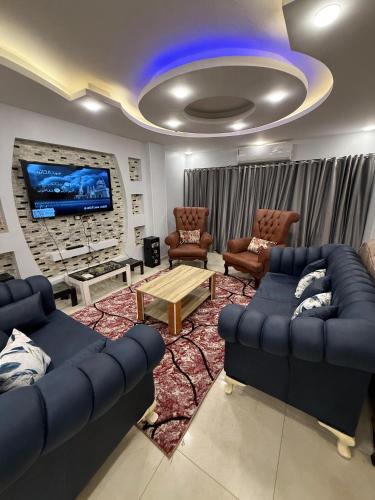 a living room with blue couches and a tv at شقة فندقية in Cairo