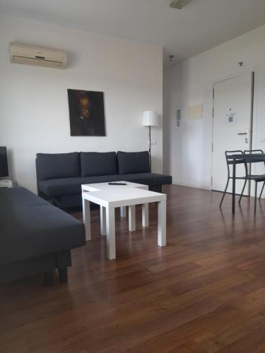 a living room with a couch and a coffee table at TOLETUM low cost LOFTS diáfanos o 2dormitorios PARKING Municipal Gratis al aire libre a 100m in Toledo