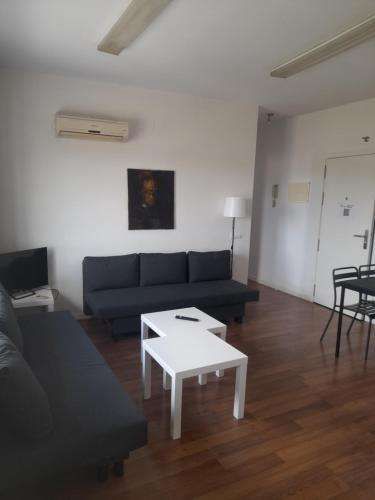 a living room with a couch and a table at TOLETUM low cost LOFTS diáfanos o 2dormitorios PARKING Municipal Gratis al aire libre a 100m in Toledo
