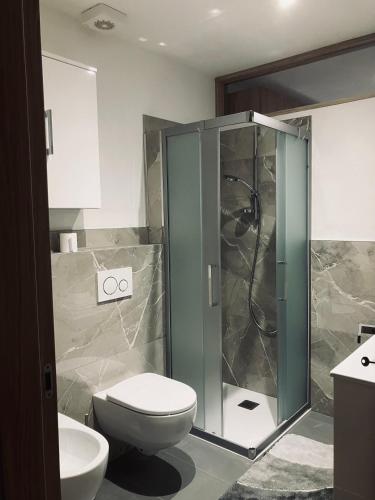 a bathroom with a toilet and a glass shower at CERMIS Minisuite in Cavalese