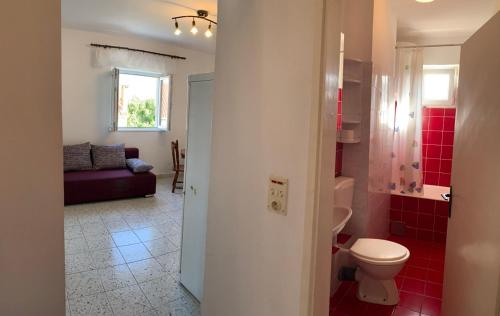 a bathroom with a toilet and red tiles at Green Apartment in Sreser
